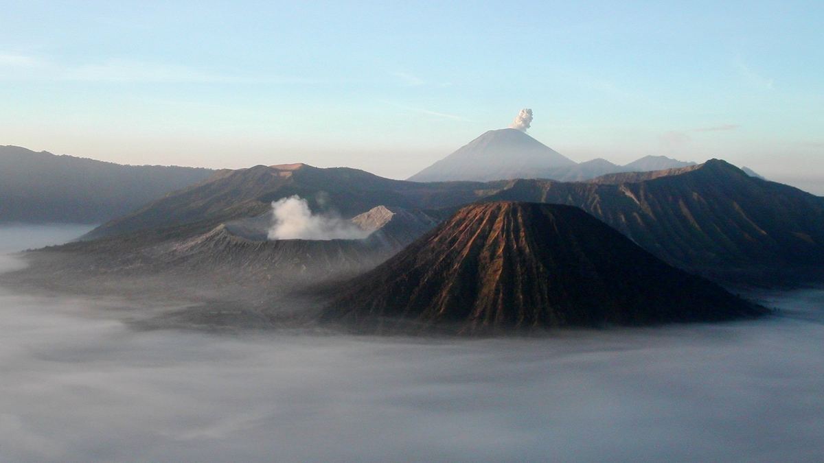 Kaldera Tengger saat matahari terbit dengan kerucut Bromo, Batok, dan Semeru di kejauhan